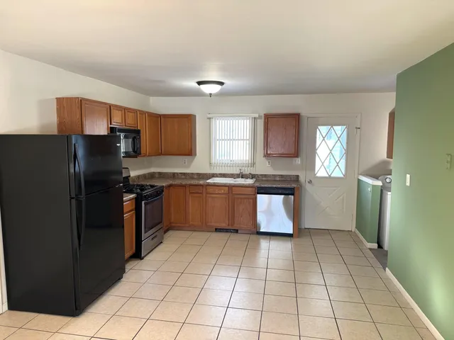 a kitchen with granite countertop a refrigerator and a sink