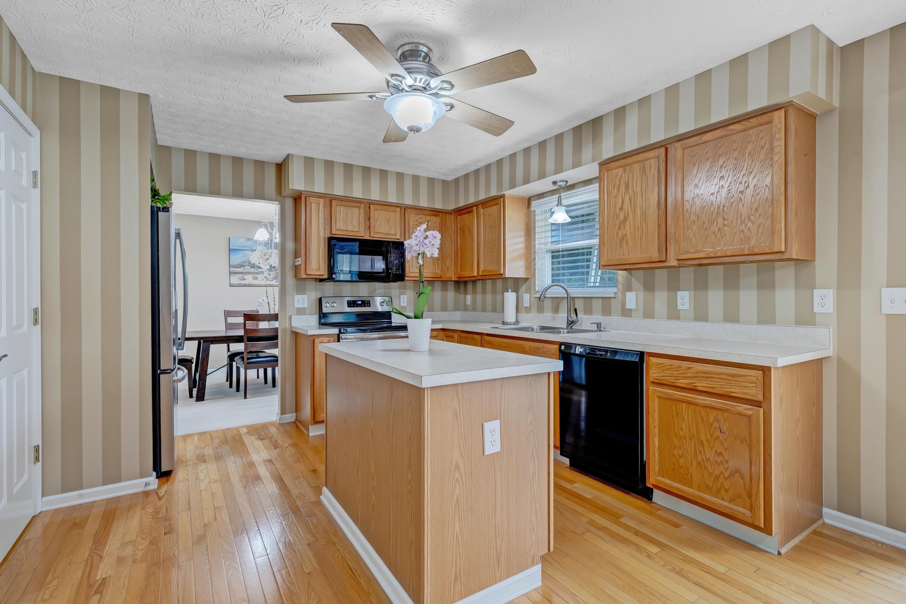 2136 Reeves Avenue Lewis Center, OH 43035 - Photo 14 of 57 • Hardwood flooring • Striped, painted walls • New General Electric® refrigerator ~ 2018 • New General Electric® range ~ 2018 • Kenmore® microwave • Kenmore® dishwasher • Oak cabinets • Center island • Double bowl, stainless steel sinktop with sprayer • Disposal • Pantry closet • 2 blinds