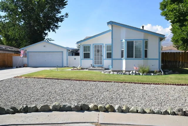 a view of a house with a yard and potted plants