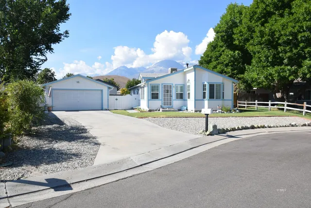 a front view of a house with a yard and potted plants