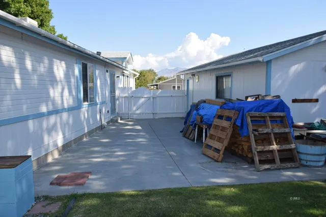 a view of a patio with table and chairs with wooden floor and fence
