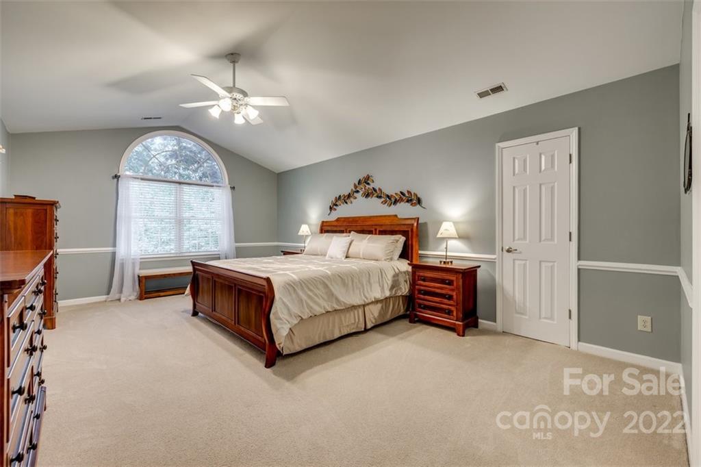 29008 Silver Fox Drive Tega Cay, SC 29708 - Photo 24 of 48 a bedroom with a bed and a chandelier