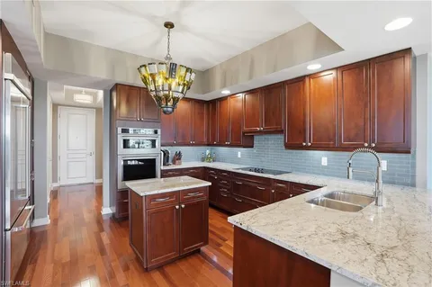a kitchen with granite countertop wooden cabinets a stove and a center island