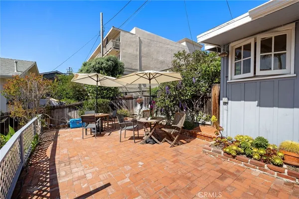 a view of a patio with table and chairs under an umbrella
