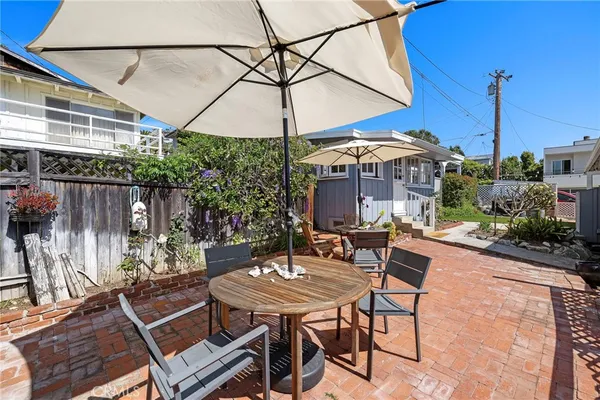 a view of a patio with a table and chairs under an umbrella