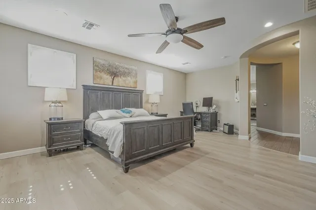 a spacious bathroom with a granite countertop double vanity sink a mirror and a bathtub