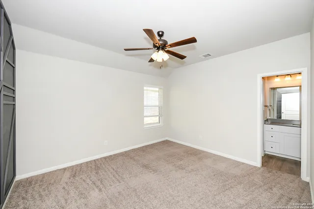 an empty room with a window and a fan