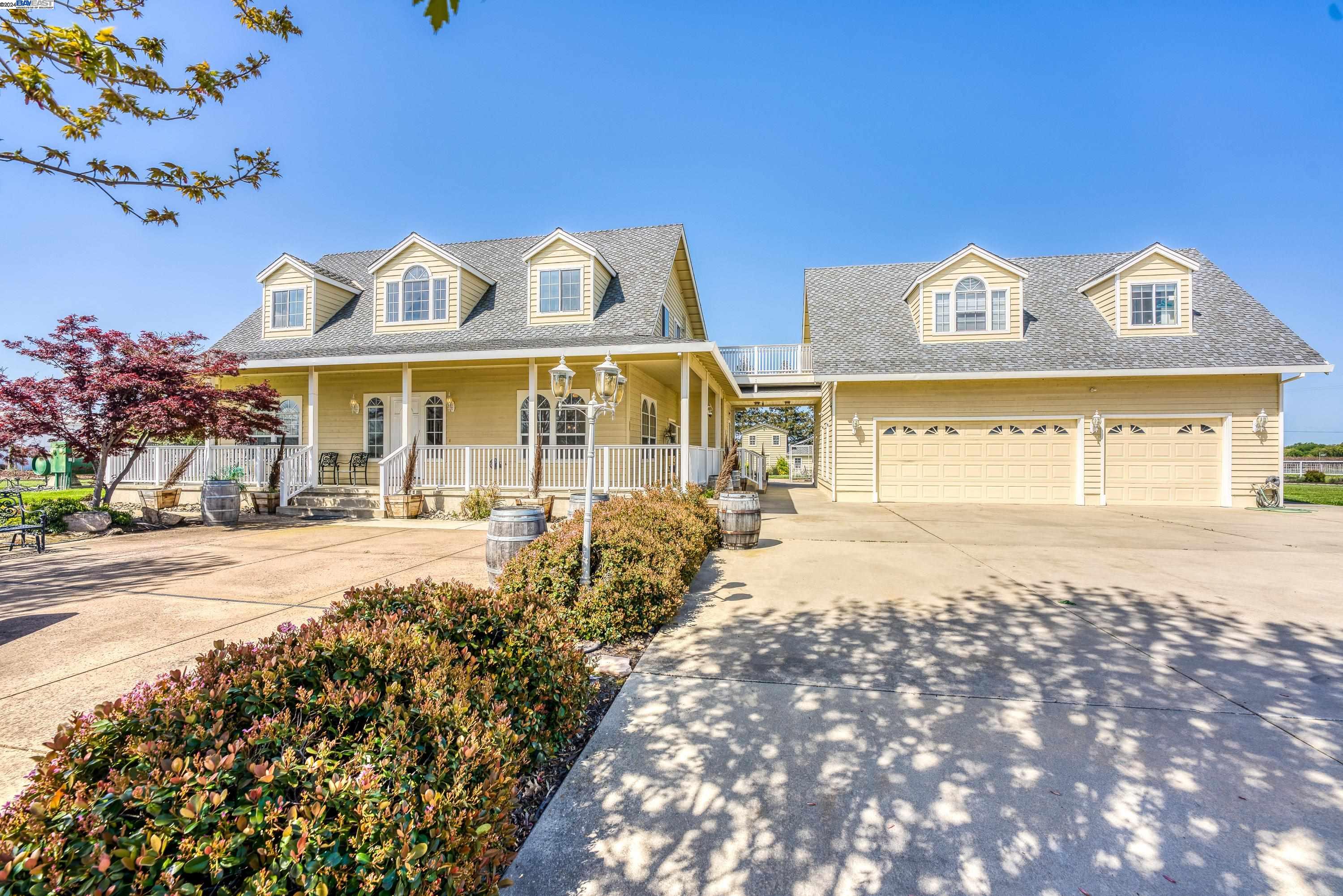 a view of a white house with a yard in the background
