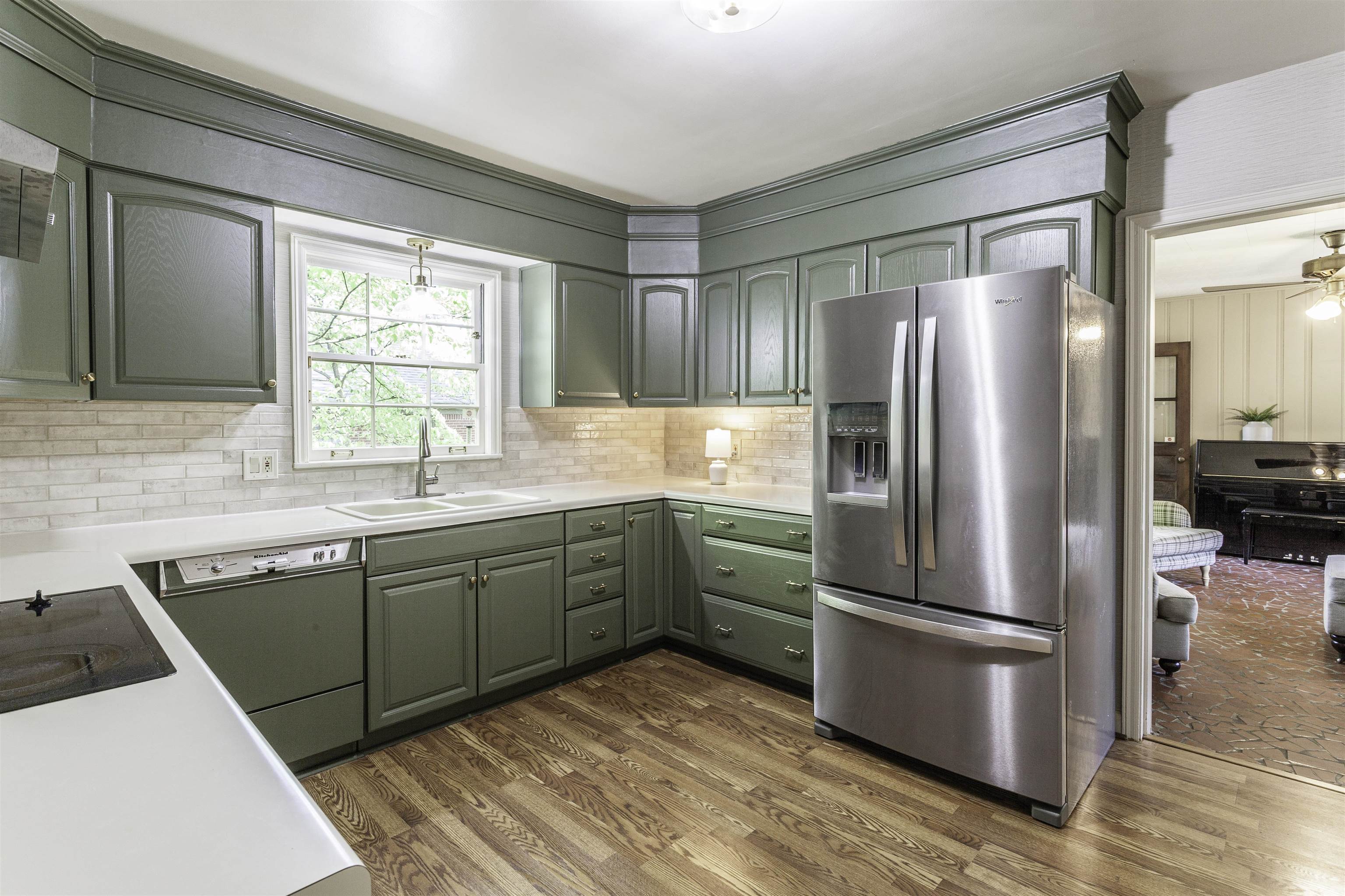 480 Colonial Road Memphis, TN 38117 - Photo 5 of 16 Kitchen featuring green cabinetry, white countertops, tile backsplash, and wood-finish flooring