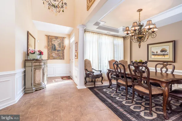 a kitchen with stainless steel appliances kitchen island granite countertop a table chairs sink and cabinets