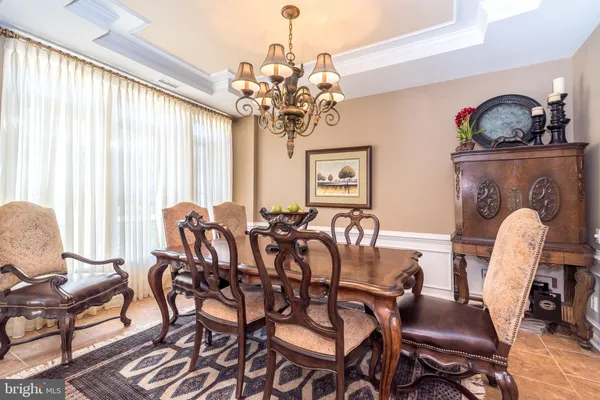 a dining room with furniture a chandelier and window