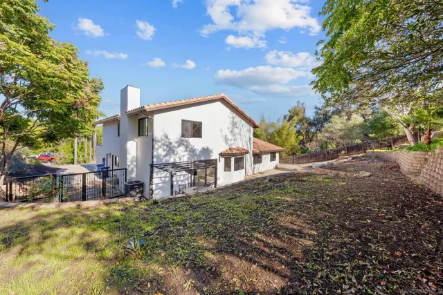an aerial view of residential house with outdoor space and trees all around