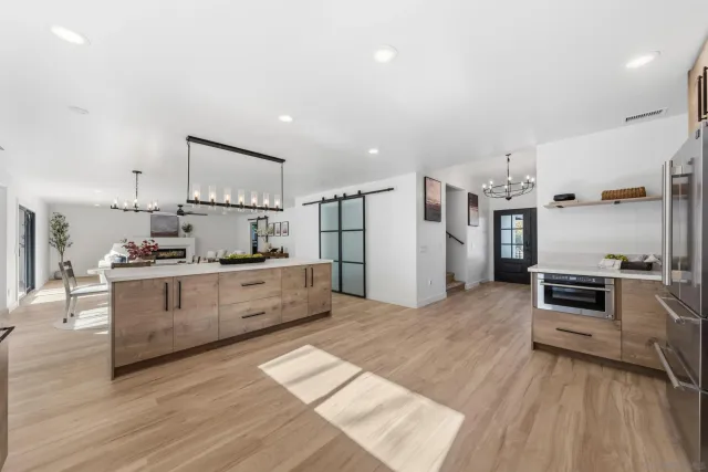 a kitchen with stainless steel appliances kitchen island wooden floors and white cabinets