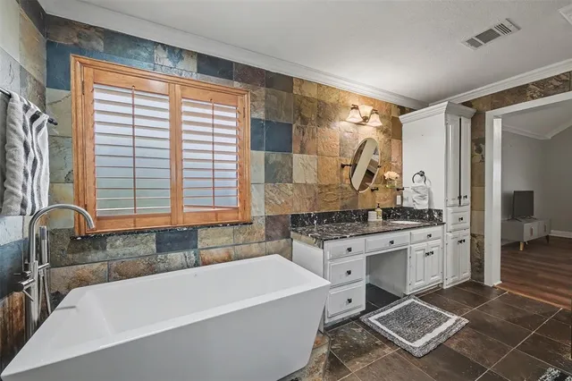 a large bathroom with a granite countertop tub sink shower and a mirror
