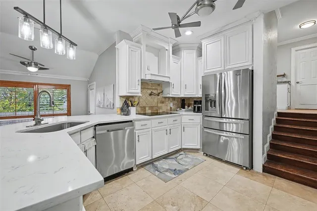 a kitchen with granite countertop a refrigerator oven a sink and cabinets