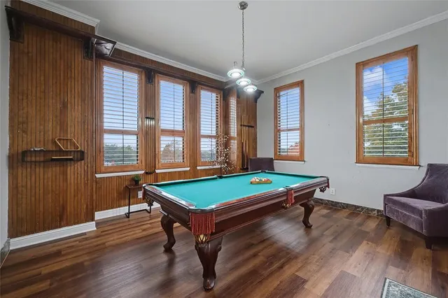 a room with pool table and windows