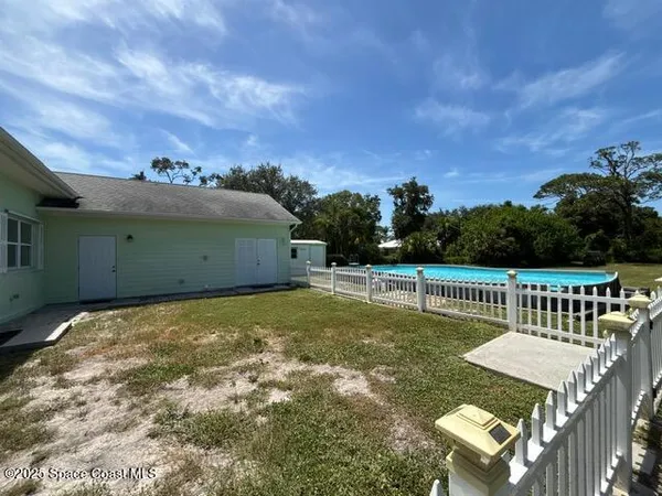 a view of a house with swimming pool and a yard