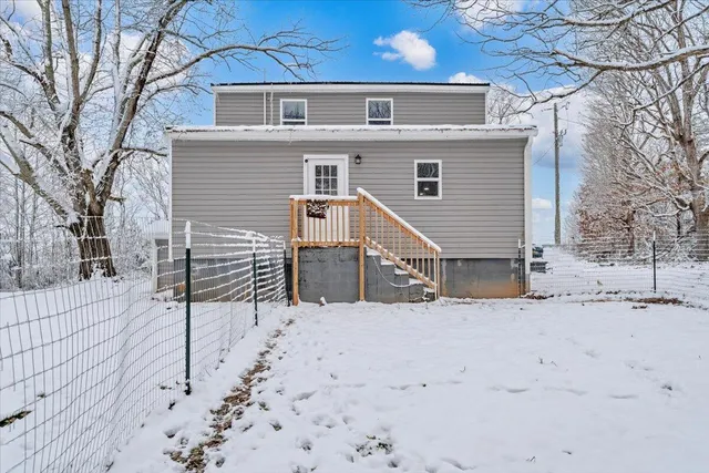 a view of a house with a yard covered in snow