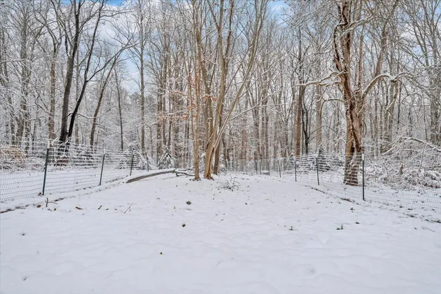 a view of a white house with large outdoor space and a car parked side of it
