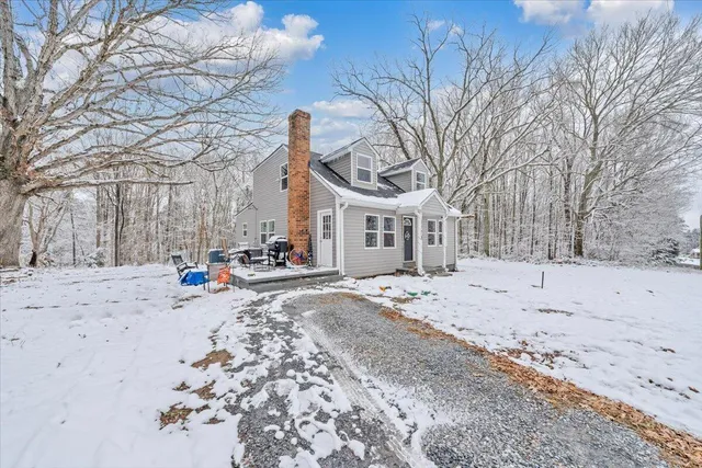 a front view of a house with a yard covered in snow