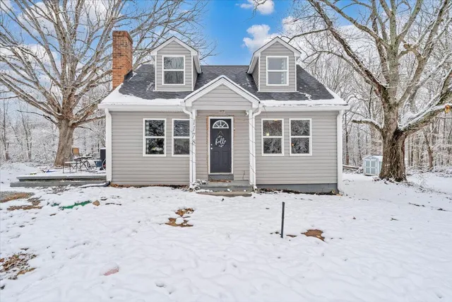 a view of a white house with a yard covered in snow