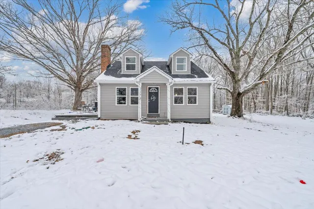 a view of white house with a snow of the yard