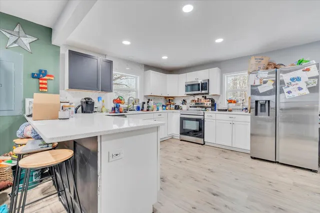 a kitchen with granite countertop a sink cabinets stainless steel appliances and a window