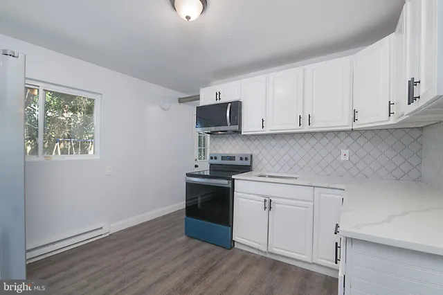 a kitchen with granite countertop white cabinets and stainless steel appliances