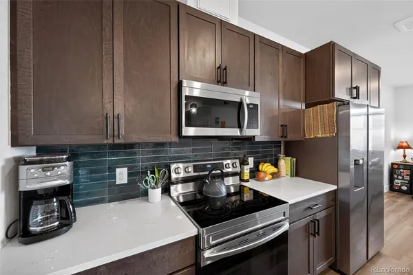 a kitchen with stainless steel appliances a stove a sink and a microwave