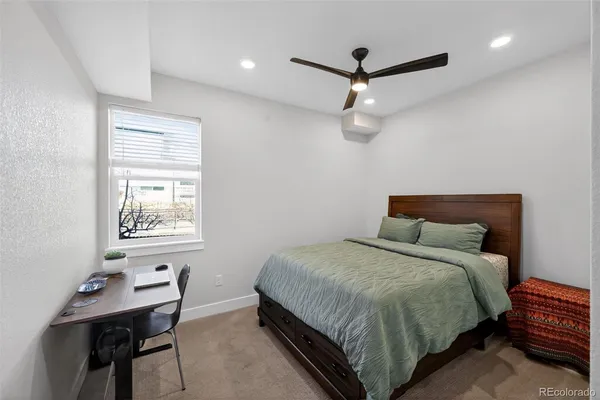a bedroom with a bed window and a desk
