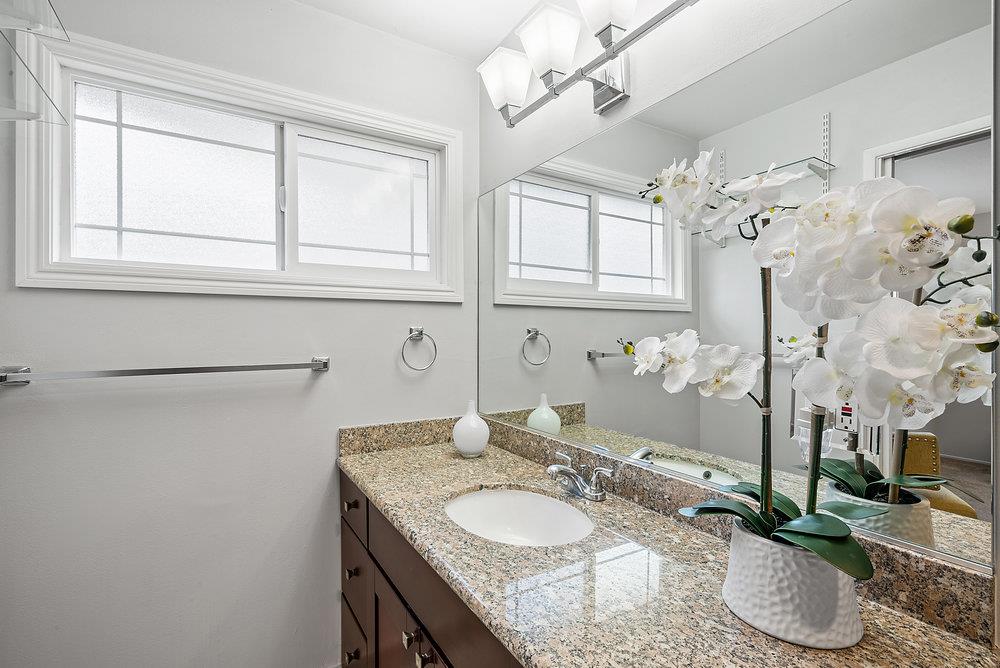 1121 Yorkshire Drive Cupertino, CA 95014 - Photo 18 of 30 a bathroom with a granite countertop sink a mirror and a shower