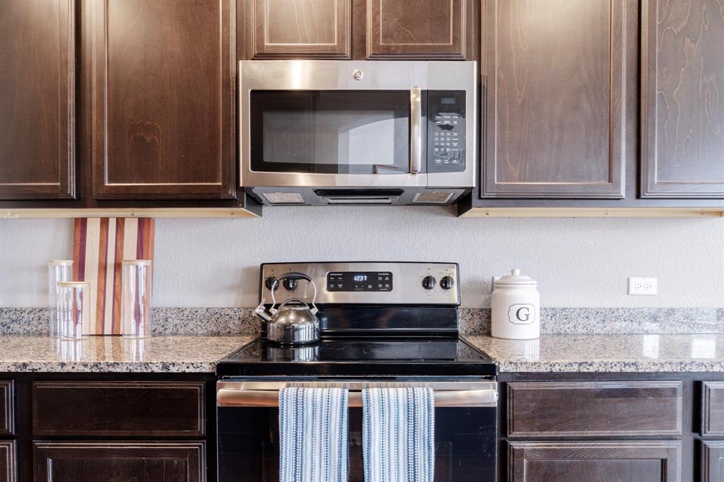 2716 Beutel Road Lorena, TX 76655 - Photo 8 of 39 a kitchen with granite countertop a stove and a microwave