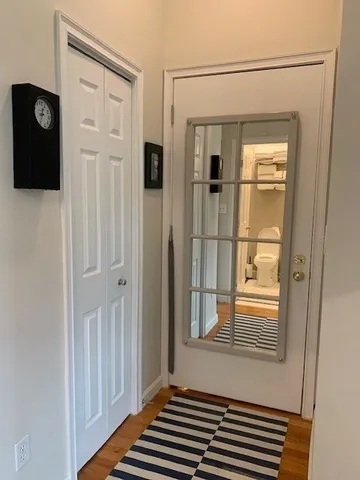 a view of a door and a bathroom with a mirror