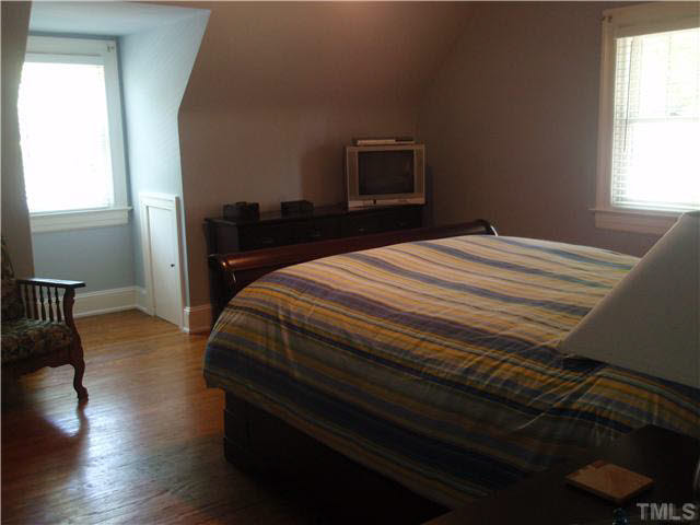 304 Brooks Avenue Raleigh, NC 27607 - Photo 13 of 14 a bedroom with a bed and wooden floor