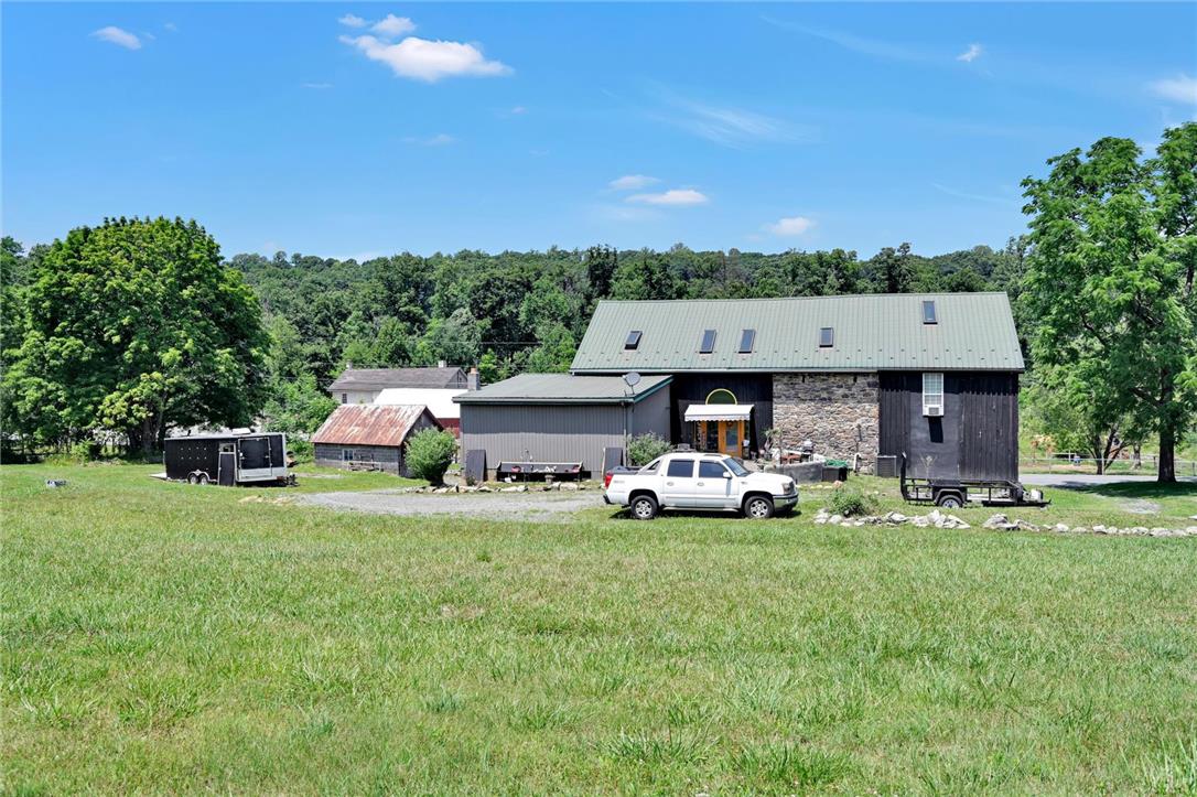 101 Conrad Road Fleetwood, PA 19522 - Photo 30 of 42 A spacious, verdant lot surrounds a charming farmhouse with a rustic aesthetic.