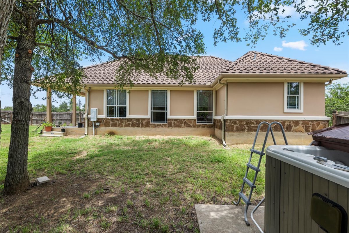 437 Balch Road Elgin, TX 78621 - Photo 26 of 37 A well-maintained stucco exterior with a tiled roof provides a private retreat with a hot tub.