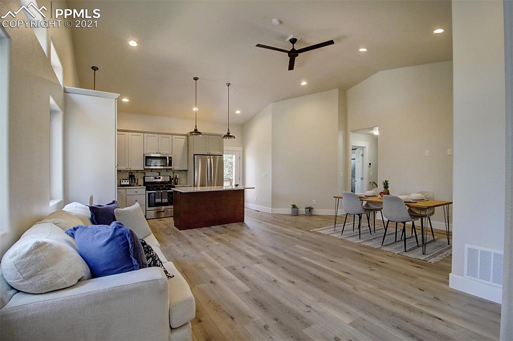 196 Shannon Place Divide, CO 80814 - Photo 7 of 25 a large living room with stainless steel appliances kitchen island granite countertop furniture and a wooden floor