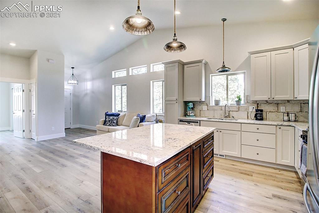 196 Shannon Place Divide, CO 80814 - Photo 8 of 25 a kitchen with a stove center island a sink cabinets and wooden floor