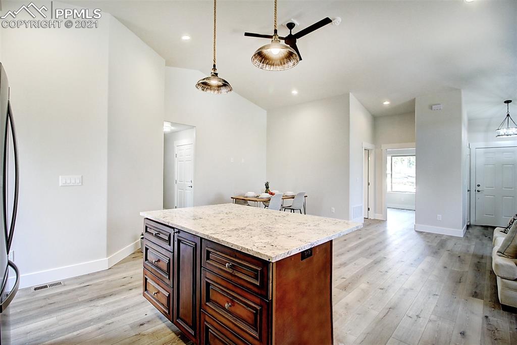 196 Shannon Place Divide, CO 80814 - Photo 9 of 25 a kitchen with a wooden floor and a refrigerator