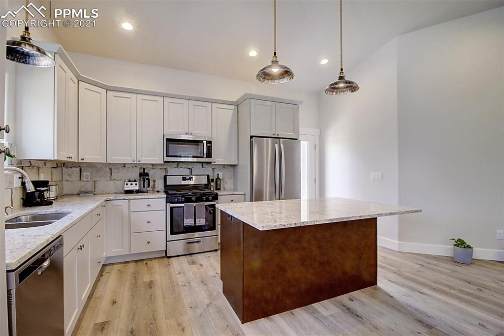 196 Shannon Place Divide, CO 80814 - Photo 10 of 25 a kitchen with kitchen island a counter top space a sink stainless steel appliances and cabinets