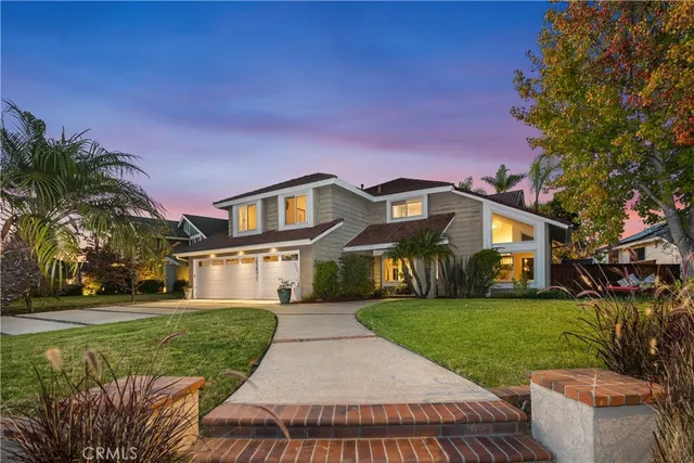 a front view of a house with a yard and potted plants