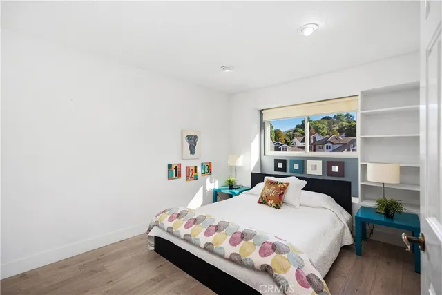 a bedroom with a bed and wooden floor