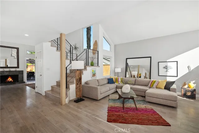 a living room with furniture a fireplace and a table with wooden floor