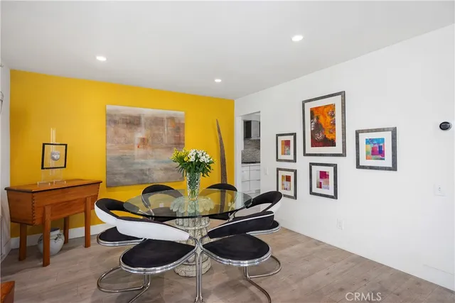a living room with furniture a rug and wall paintings