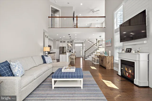 a kitchen with stainless steel appliances granite countertop a stove a refrigerator a kitchen island a dining table and chairs with wooden floor