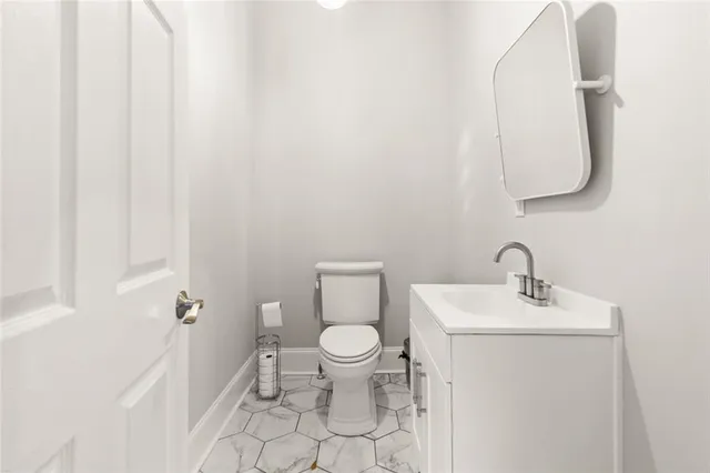 a bathroom with a toilet sink and mirror