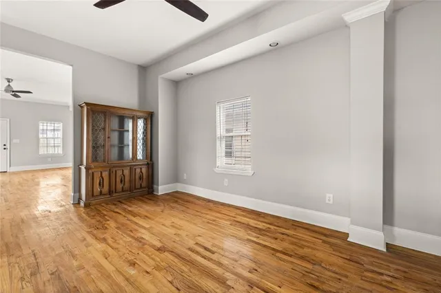 an empty room with wooden floor and windows