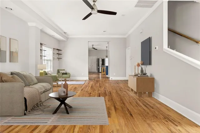 a living room with furniture and a wooden floor