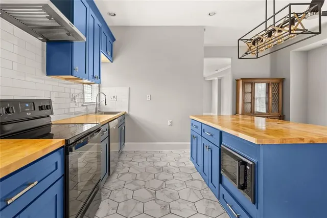 a kitchen with stainless steel appliances granite countertop a sink and a stove