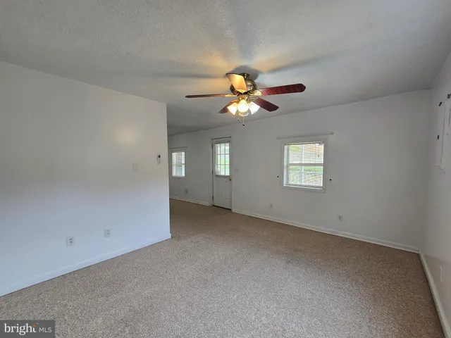 an empty room with a empty space and a ceiling fan